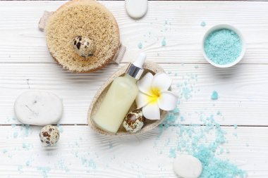 Beyaz ahşap zemin üzerinde spa prosedürleri, çiçek ve Paskalya yumurtaları için aksesuarlar ve ürünler