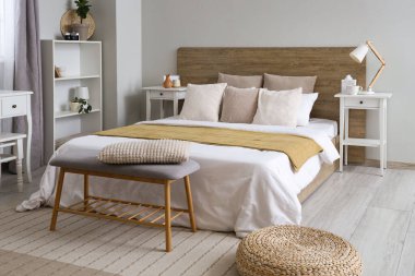 Büyük yataklı, raflı ve komodinli modern yatak odası.