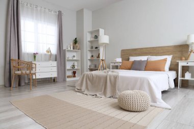 Büyük yataklı, raflı, çekmeceli ve komodinli modern bir yatak odası.