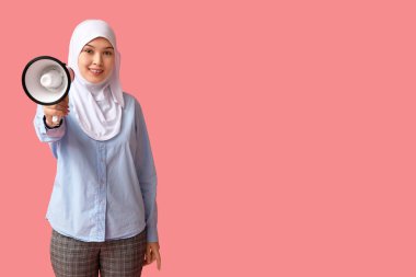 Pembe arka planda megafonu olan genç Asyalı Müslüman kadın. Ulusal Duyulma Günü