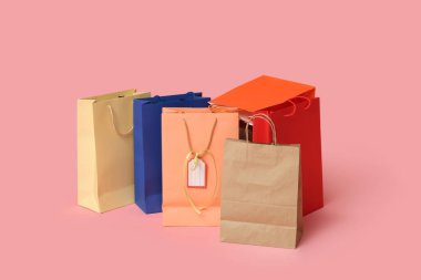Pembe arka planda bir sürü alışveriş çantası