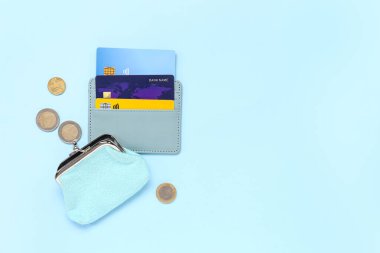 Mavi kredi kartı, kart, çanta ve bozuk para içeren kompozisyon