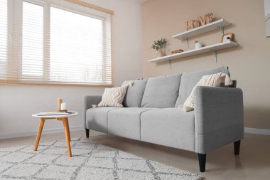 Kanepesi, masası ve rafları olan şık bir oturma odası.