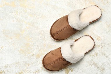 Açık grunge arka planda bir çift kahverengi yumuşak terlik. Üst görünüm