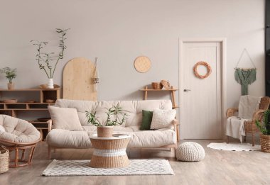 Kahve masasında, koltukta ve beyaz koltukta bambu sapları olan hafif oturma odasının şık bir iç mekanı.