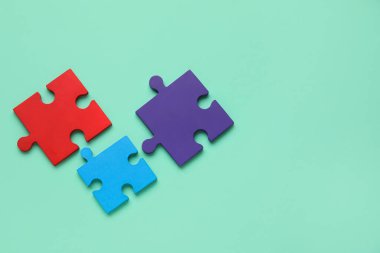 Turkuaz arka planda renkli yapboz parçaları. Otistik bozukluk kavramı. Üst görünüm