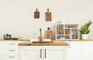 Ahşap tezgah, mutfak iç kısmında kesim tahtası ve bardak.