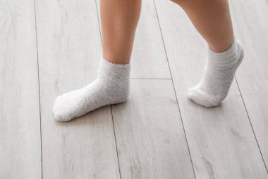 Çoraplı kadın lamine zeminde yürüyor, yakın plan.