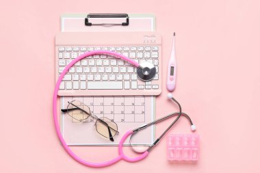 Pembe arka planda tıbbi malzeme, klavye ve takvim bileşimi