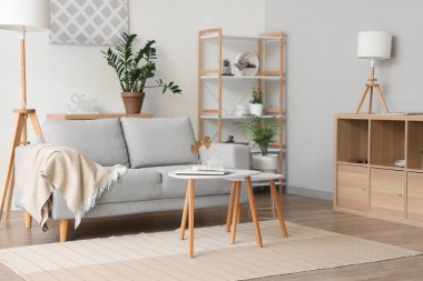 Kanepe, ekose, raf ünitesi ve sehpası olan bir oturma odası.