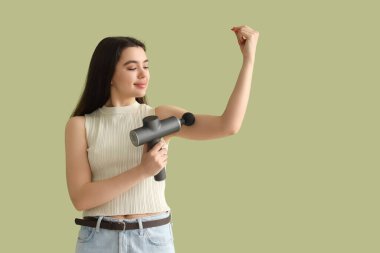 Koluna yeşil arka planda vurmalı masaj yapan genç bir kadın.