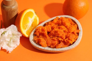 Renkli arka planda doğal vücut fırçası, çiçek ve portakallı plaka