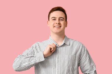 Handsome young man in stylish striped collar shirt on pink background
