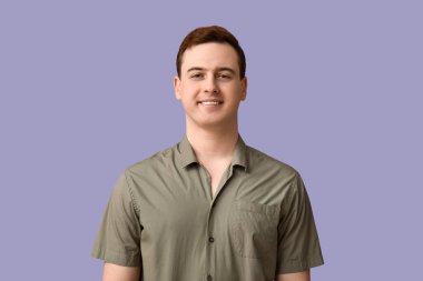 Handsome young man in stylish green collar shirt on lilac background