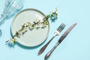 Mavi arkaplanda çiçek açan dalları olan güzel masa ayarları