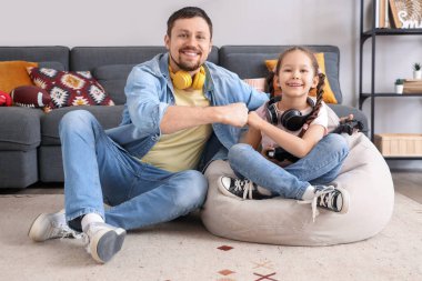 Mutlu baba ve küçük kızı evde yumruk tokuşturuyorlar.