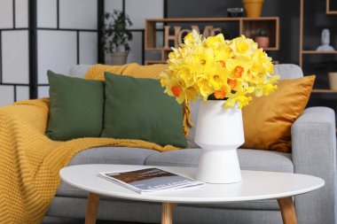 Çiçekli vazo, kanepe ve kahve masası güzel oturma odasında, yakın plan.