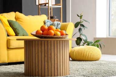 Süslü oturma odasındaki sehpanın üzerinde narenciye tabağı var.