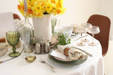 Düğün kutlaması için nergis ve mumlarla dolu güzel bir masa.