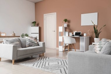 Koltukları ve işyeri olan şık bir oturma odası.