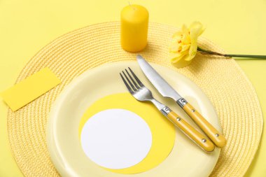 Güzel çiçekli şık masa ve sarı arkaplanlı mum.