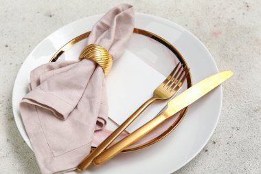 Beyaz arka planda altın çatal bıçak seti olan güzel bir masa.