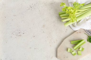 Beyaz zemin üzerinde taze yeşil kereviz kesilmiş tahta