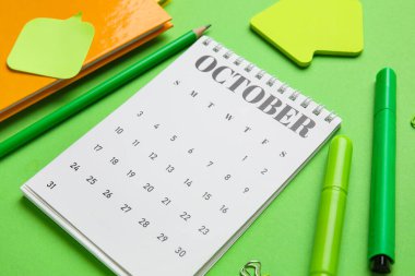 Yeşil arkaplanda ofis kırtasiyesiyle takvim