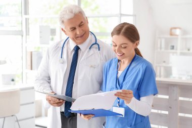 Klinikte çalışan olgun doktor ve hemşire.