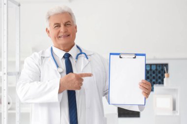 Klinikteki panoya bakan olgun bir doktor.