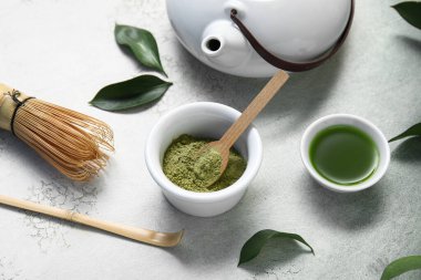 Bir kase kibrit çayı ve pudra ile arkaplanda chasen.