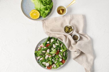 Lezzetli salata ve hafif arka planda malzemeler içeren kompozisyon