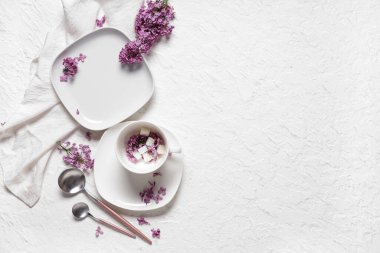 Beyaz grunge arkaplan üzerinde leylak çiçekleri ile güzel masa ayarları