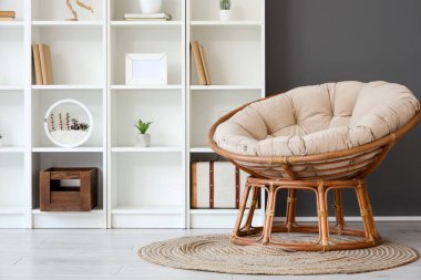 Rahat koltuğu ve raf ünitesi olan modern oturma odası.