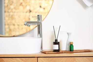 Lavabo, aroma yayıcı ve kozmetik ürünler banyoda.