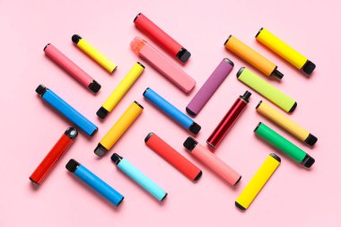 Pembe arka planda farklı elektronik sigaralar.