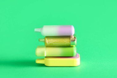 Yeşil arka planda farklı elektronik sigaralar.