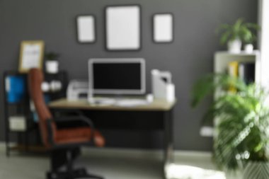 Çalışma odası, koltuk, modern bilgisayar ve siyah duvarın yanındaki raf ünitesi, bulanık görünüm