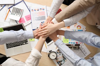 İş adamları ellerini masaya koyuyor.