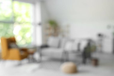 Bulanık oturma odası, gri kanepe, koltuk ve puf.