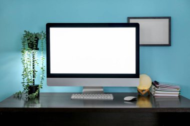 Ev bitkisi, parlayan lamba ve modern bilgisayarlı şık bir iş yeri.