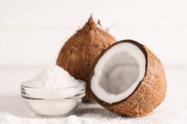 Taze hindistan cevizi ve beyaz masada gevrekli cam kase.