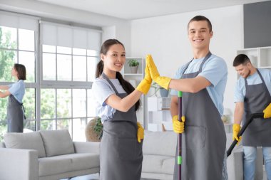 Genç hademeler odada birbirlerine beşlik çakıyorlar.