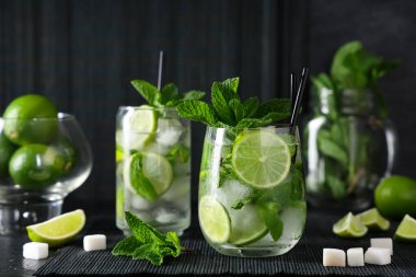 Siyah arka planda limonlu ve naneli taze mojito kokteyli.