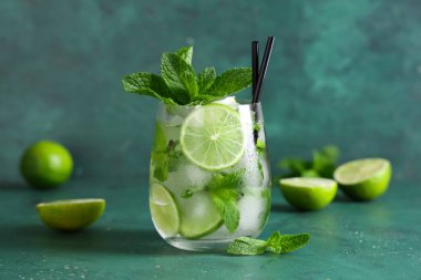 Yeşil arka planda taze mojito kokteyli ve nane şekeri.