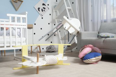 Depremden sonra mobilyaların devrildiği dağınık bir çocuk odası.