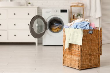 Çamaşır makinası ve kirli çamaşırlarla dolu sepet.