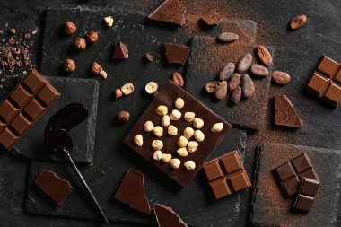 Fındıklı çikolata, kakao çekirdeği ve koyu arkaplanda pudra.