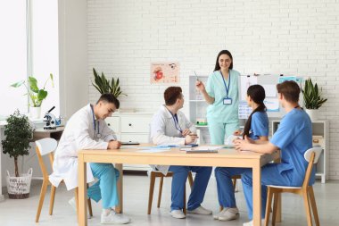Klinikte meslektaşlarıyla birlikte çalışan kadın doktor.