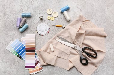 Gri arkaplanda renk örnekleri olan aksesuarlar dikiyorum. Üst görünüm